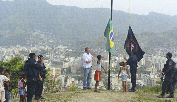 Hasteando a bandeira brasileira e a do Bope no alto do Morro dos Macacos, onde um helicóptero da PM foi abatido em 2009