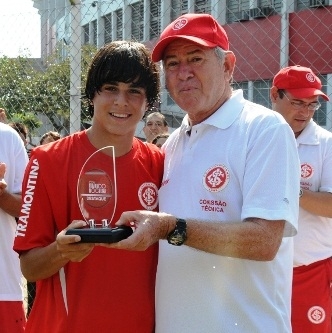 Com um dos diretores da base do Inter exibindo um de seus muitos troféus de melhor jogador