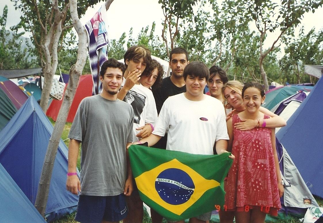 Thiago Carneiro (guitarrista da primeira formação do MQN - primeiro a esquerda), Fabrício Nobre (com a bandeira) e amigos espanhois no camping do festival de Benicassin (Espanha, 1997)