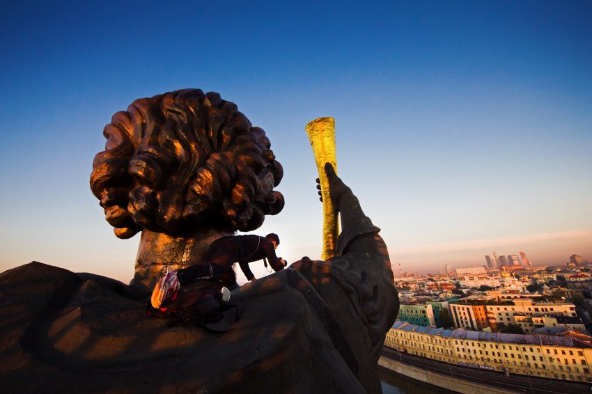 Marat Dupri nos ombros da estátua gigante do Czar Pedro, o Grande, em Moscou