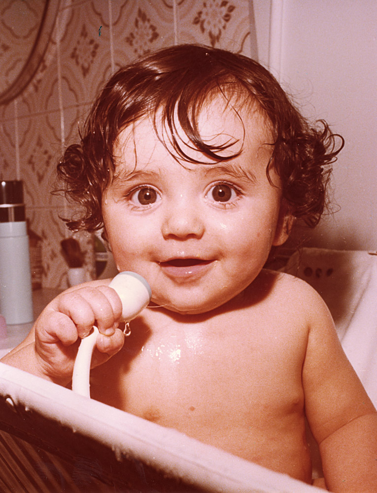 No banho, com 1 ano, fazendo  o chuveiro de microfone