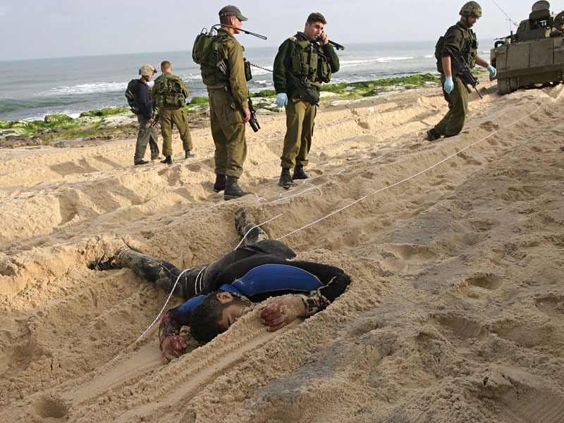 Soldados israelenses e uma de suas vítimas no litoral de Gaza