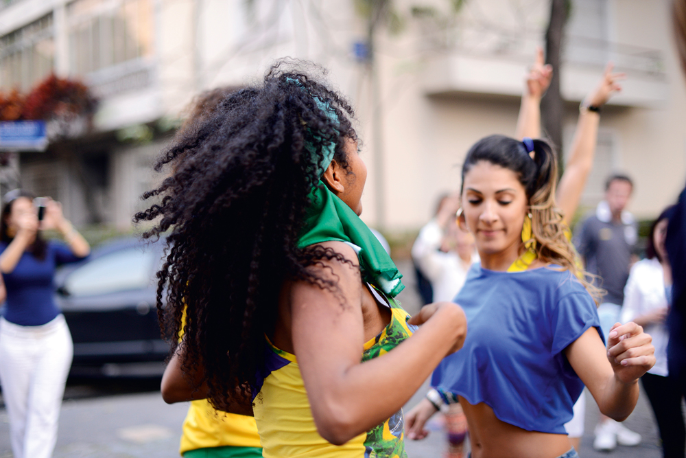São Paulo, 19h: A designer Estefi Machado fotografa garotas dançando no bairro de Pinheiros após o 0x0 com o México