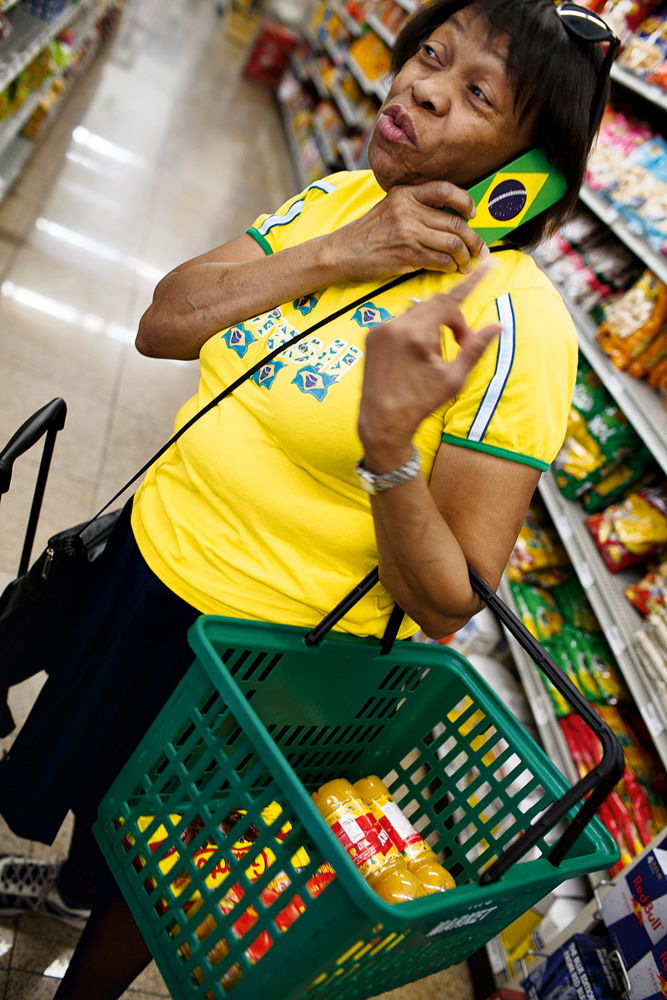 Nova York, 11h: A fotógrafa Fernanda Lenz flagra imigrante brasileira comprando suco de caju e chocolates para devorar durante a partida