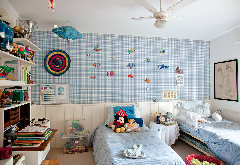 Boa ideia  - No quarto dos meninos, uma das paredes foi forrada com tecido estampado – que eles aproveitam para colar adesivos e desenhar em cima