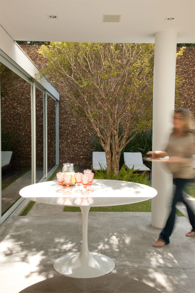 Lado de fora  No jardim, a mesa Saarinen recebe a família e os amigos nos fins de semana. Ao fundo, espreguiçadeiras Tok & Stok