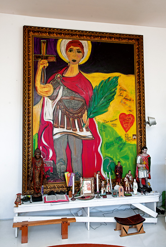 Devoção - O enorme quadro de Santo Expedito, da artista plástica Isabelle Tuchband, serve como altar para os santos de todas as crenças. O banquinho indígena é da galeria Brasiliana  Fiscal