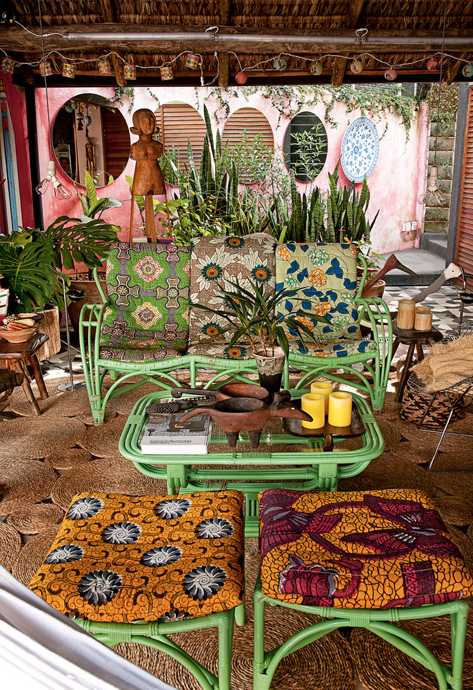 Estampa étnica - Na varanda, os móveis de vime da avó de Marcelo foram pintados e ganharam tecidos africanos trazidos de viagens. Na parede, o prato veio da Turquia e os espelhos foram encomendados por Cris