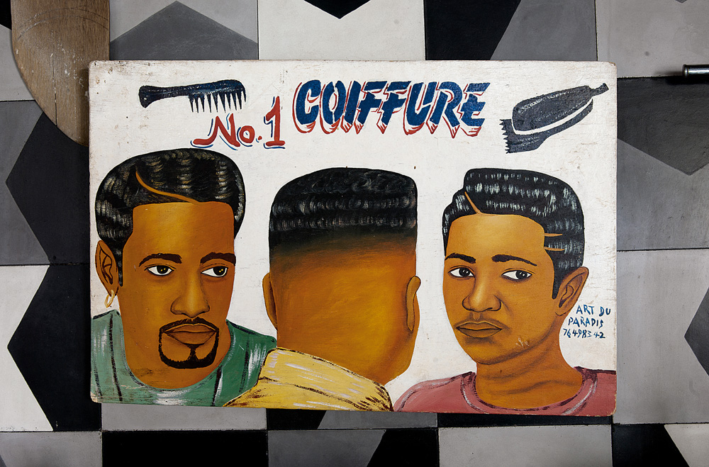 Profissional - A placa de cabeleireiro trazida da África fica encostada em parede revestida por ladrilho hidráulico desenhado por Marcelo para a Brasil Imperial