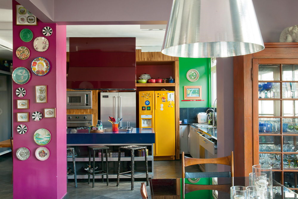 Coração - A cozinha é a área preferida dos amigos e o centro da casa. Fawsia teve que repintar as paredes algumas vezes para conseguir chegar neste resultado de cores. A luminária de metal é de Philippe Starck