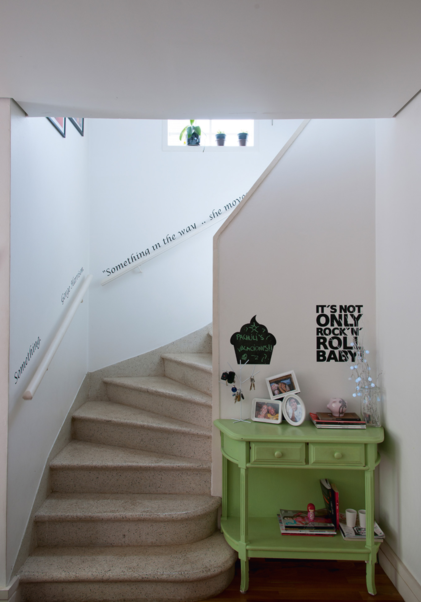 Escada musical: Nas paredes da escada, adesivo com a letra da música “Something” de George Harrisson, feito na Grudado. O móvel verde era da mãe de Ana