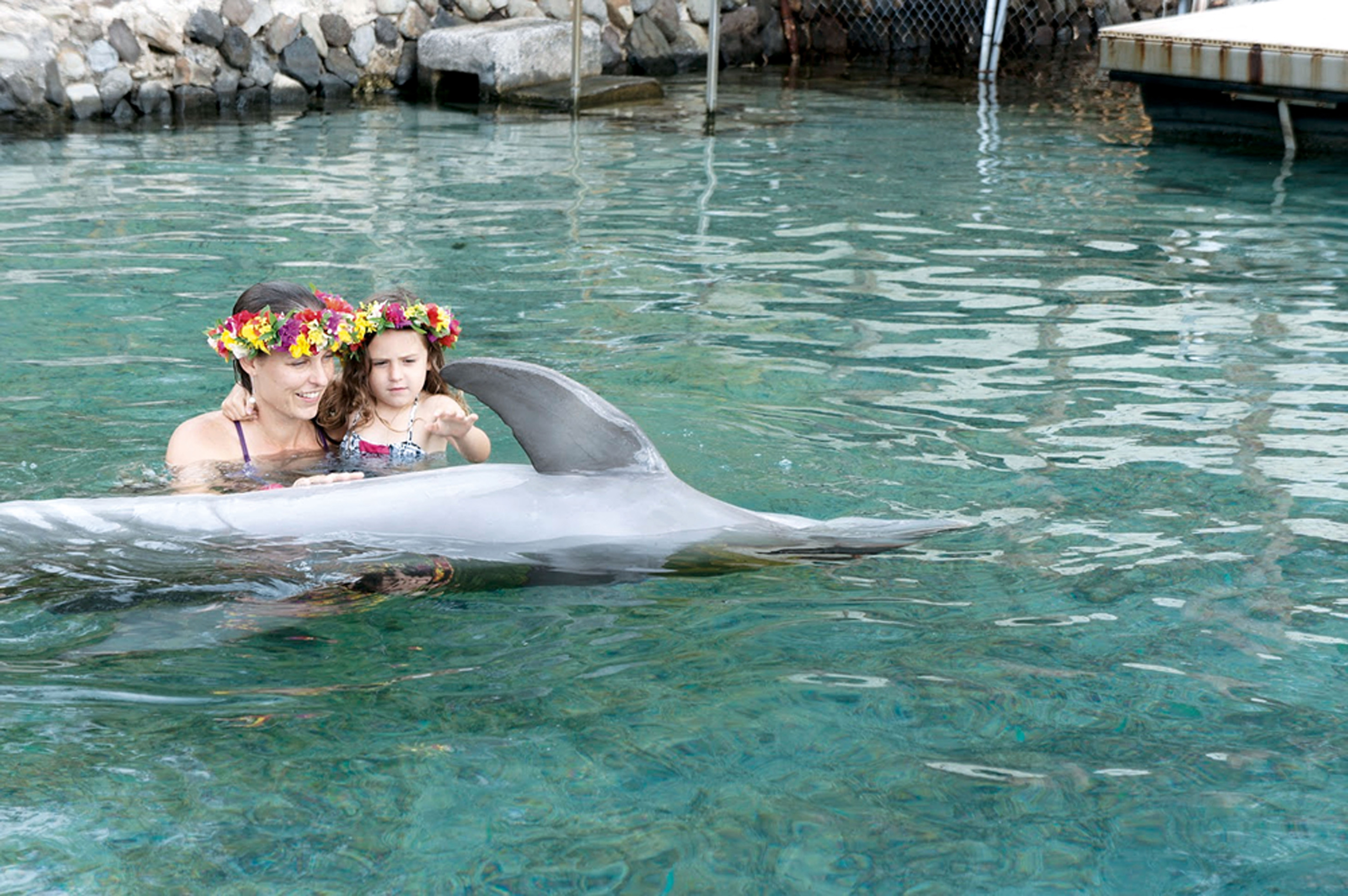 Mãe e filha com os golfinhos, no Taiti