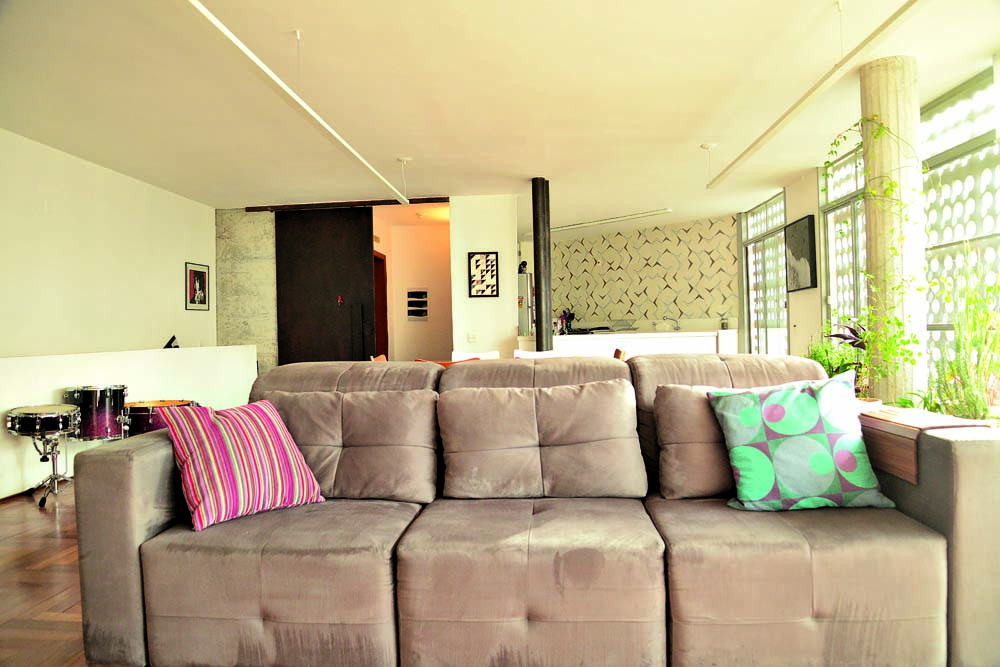 Neutro: O sofá Formatto fica na sala do andar de baixo, integrada à cozinha aberta (ao fundo). O desenho dos azulejos é da própria Renata. Almofadas de Fernando Jaeger e quadros de Thalita Hamaoui