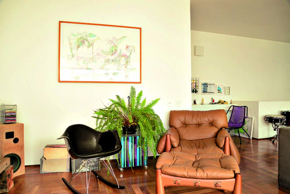 Cantinho: Entre a cadeira de balanço Charles Eames e a poltrona Mole, de Sergio Rodrigues, cubo listrado da Moyou. Na parede, quadro de Thalita Hamaoui. Ao fundo, cadeira de macarrão herdada da avó