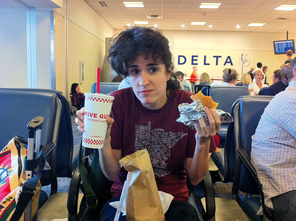 18:15 “No aeroporto de Atlanta, depois de andar muito procurando algo para comer. Ana e Lovefoxxx acharam a rede de fast-food local Five Guys.”