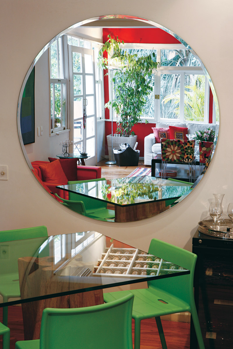 DE PROFUNDIS As cadeiras são de Philip Starck, a mesa é e Cláudio Bernardes. O espelho redondo projetado pela arquiteta Roberta Moura reflete a varanda cheia de verde. Lá fora, as plantas dividem espaço com uma horta com 12 tipos de tempero