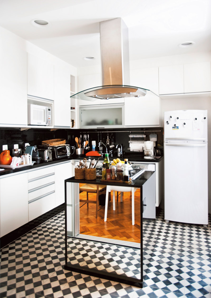 O chão de ladrilho hidráulico imita desenho dos anos 50 e deixa a cozinha com cara de bistrô francês. O espelho aumenta o ambiente