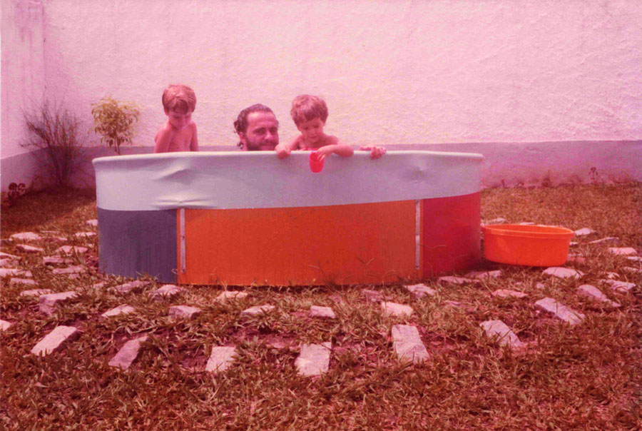 Com o pai e irmão na piscina de casa