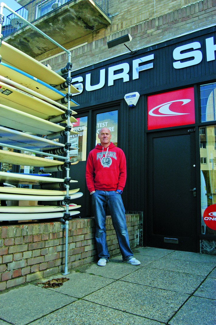 Shaun Taylor em sua surf shop, que ele abriu ao ouvir os rumores sobre o recife artificial