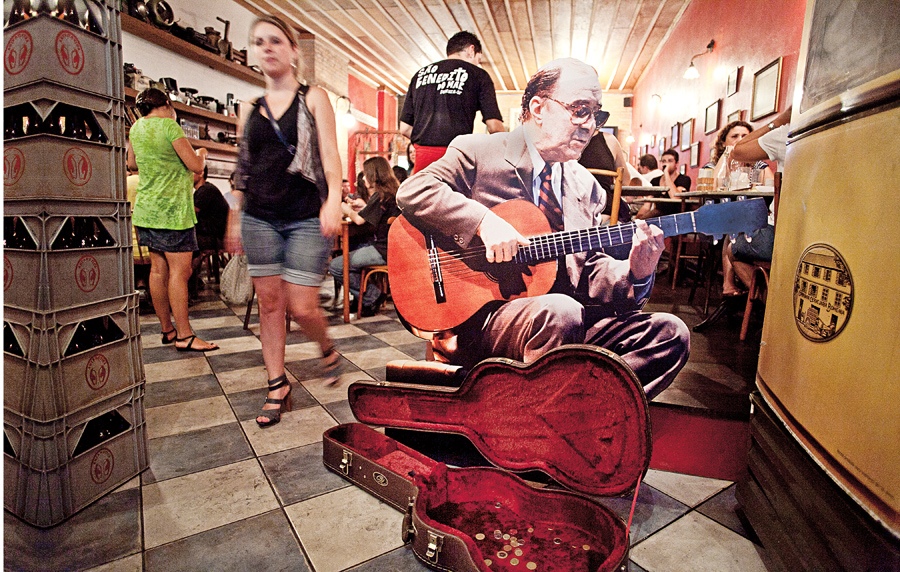Um cantinho, um violão e um display de João circulando por São Paulo. Num restaurante da praça Benedito Calixto