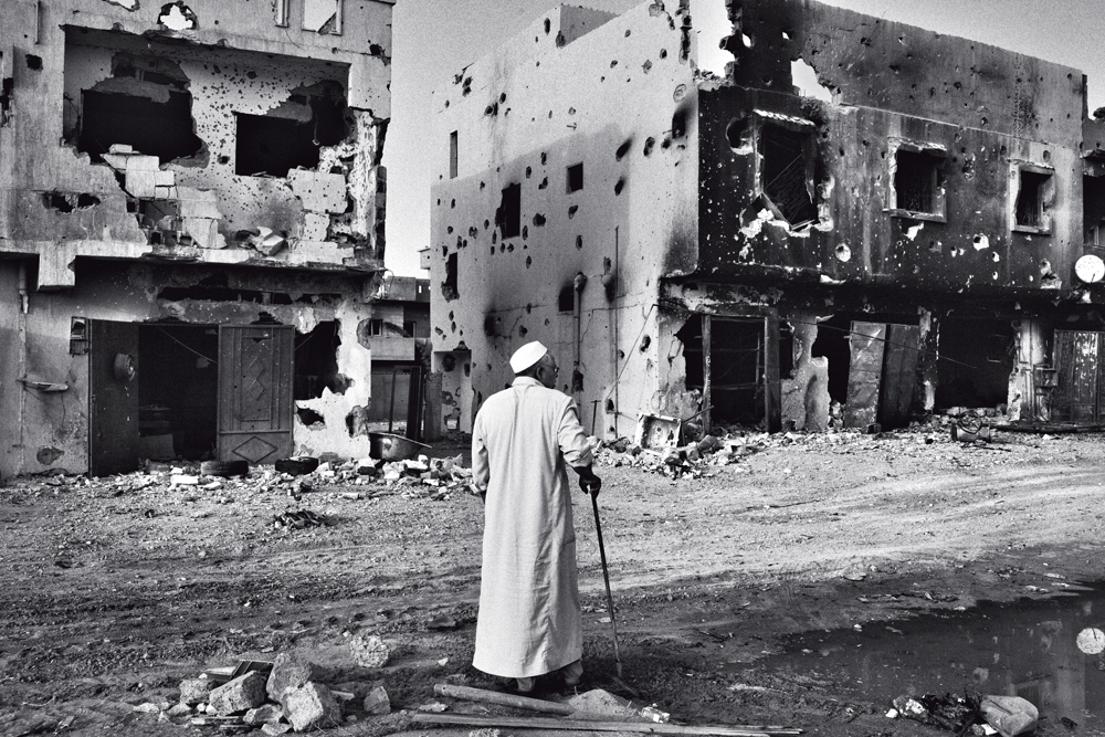 Morador observa a destruição da guerra em mais uma imagem de Maurício Lima feita para o New York Times na cidade síria de Sirte ano passado