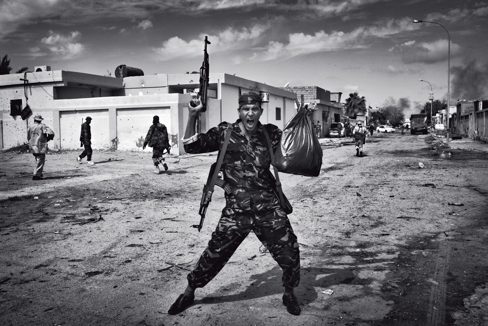 Na Líbia, rebelde comemora após achar rifles e munição em uma área residencial da cidade de Sirte. O brasileiro Maurício Lima fez essa foto quando esteve no país ano passado, trabalhando para o The New York Times