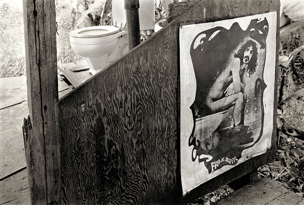 Banheiro adornado com pôster de Frank Zappa