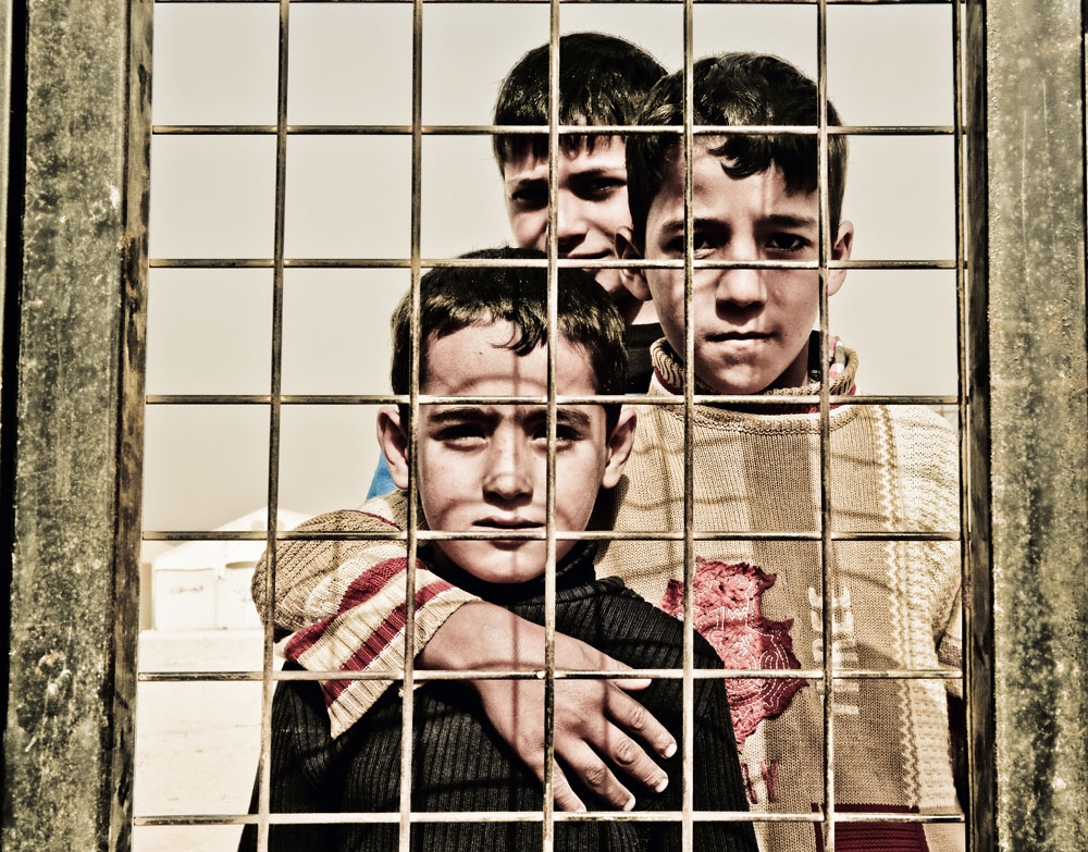 Meninos à espera da triagem do campo de refugiados de Al Zaatari