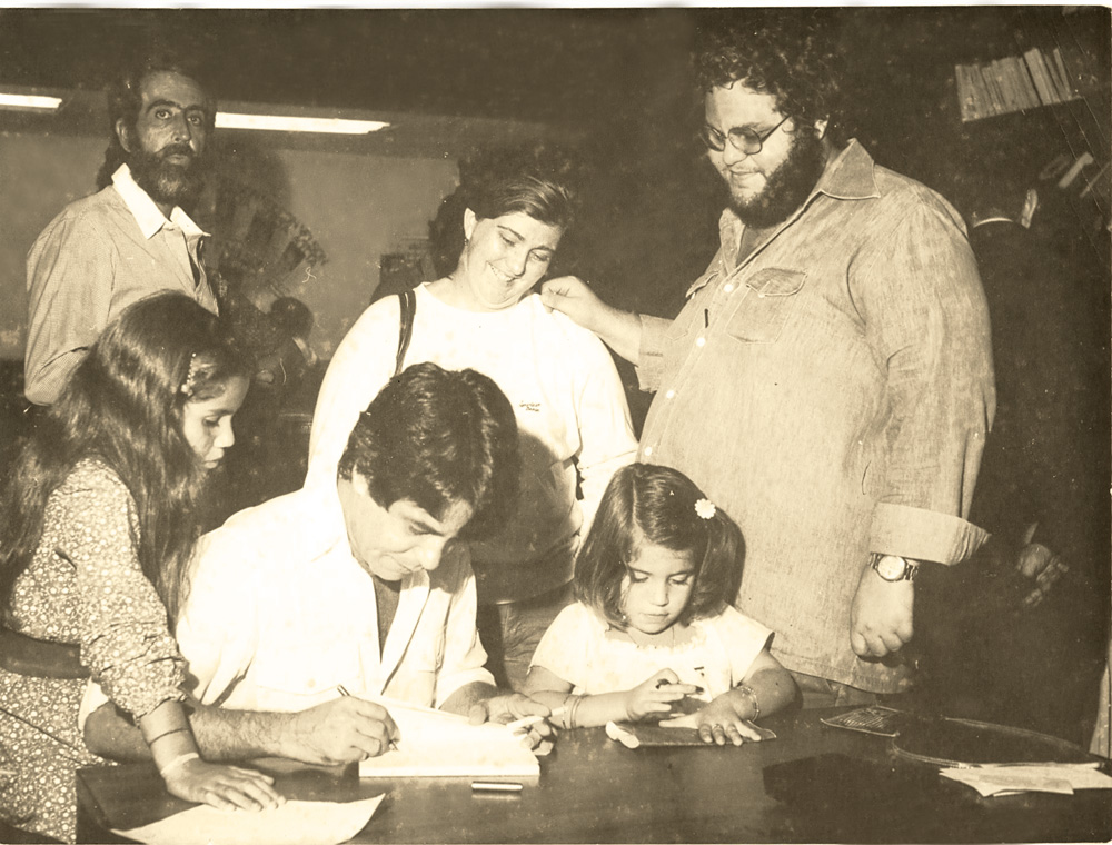 Nelson autografando seu primeiro livro Música humana música, em 1978, entre as filhas Joana e Esperança