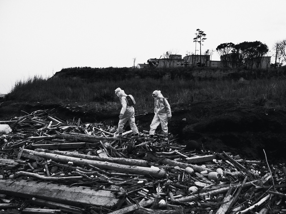 A dupla de artistas indonésios Tita Salina e Irwan Ahmett, caminhando pelos destroços varridos pelo tsunami na praia