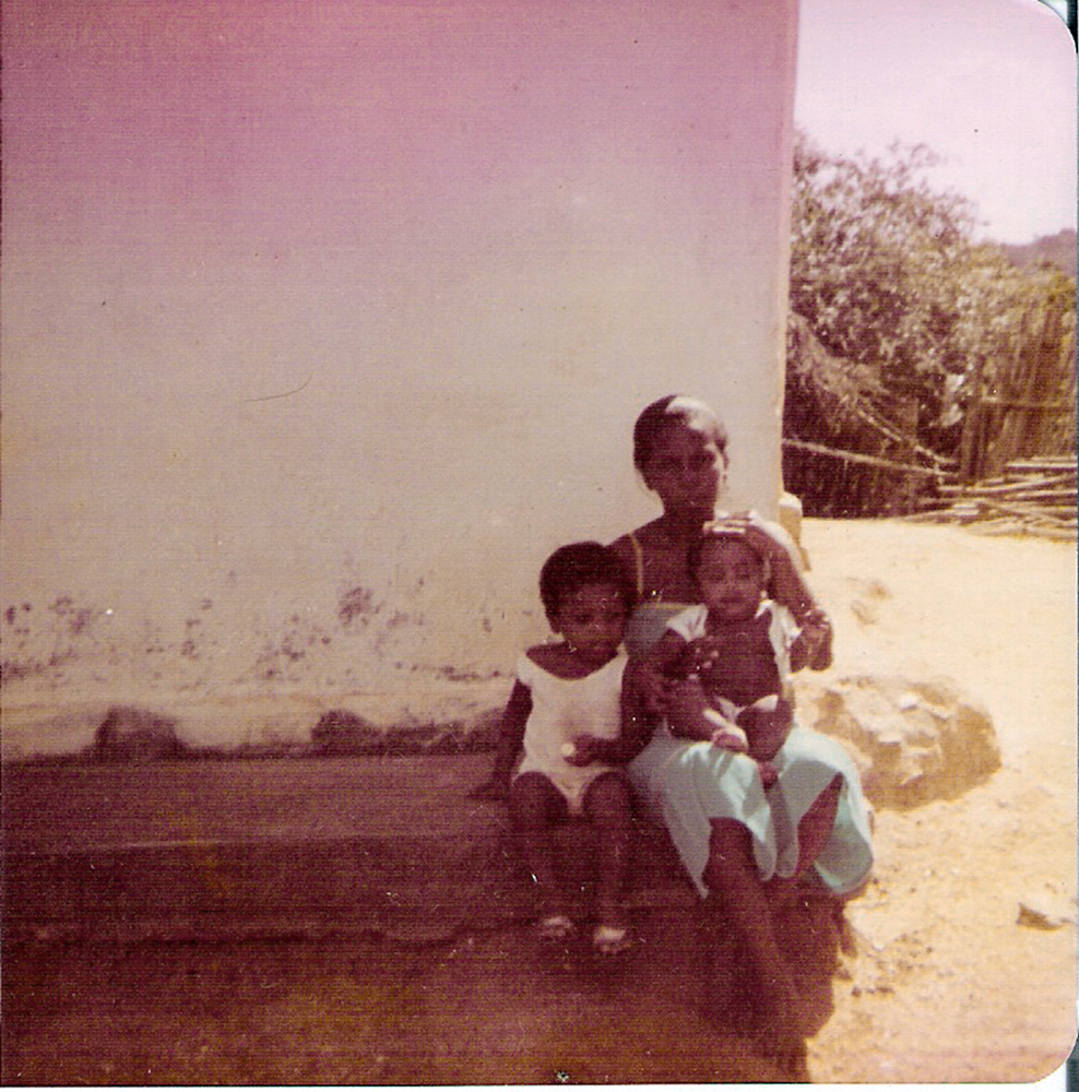No colo da mãe, Célia, junto com um primo na Bahia