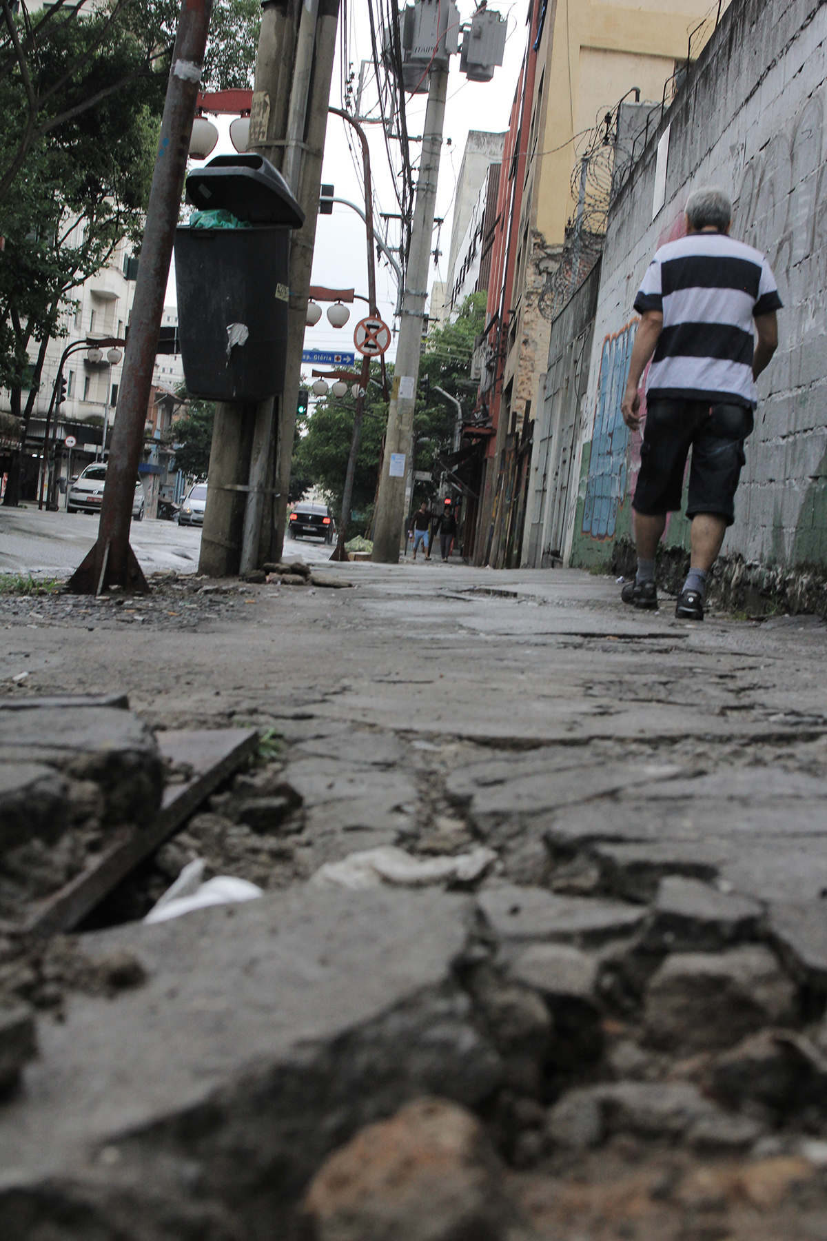 Rua Barão de Iguape, perto do nº 222, Liberdade: o que era um caminho de pedestres parece ser engolido pelo bueiro. Ainda assim, há quem ande