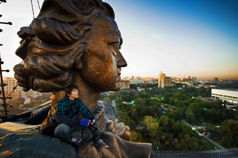 Marat Dupri nos ombros da estátua gigante do Czar Pedro, o Grande, em Moscou