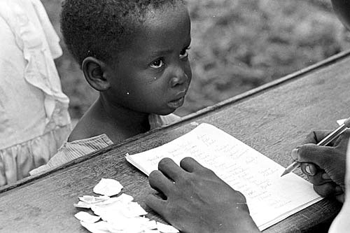 Conflito de Biafra, 1968. Menino espera cupons para receber leite e peixe em um centro de nutrição. (H. D. Finck/CICV)