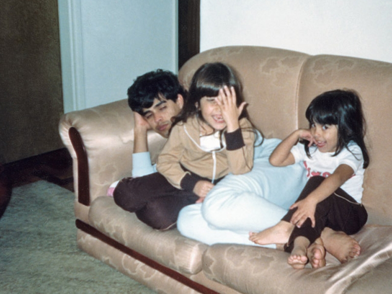 Com cara de sapeca – e mão no rosto – no apartamento da Mooca, aos 5 anos, com o pai e a irmã, Camila