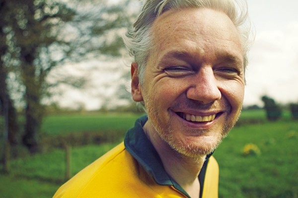 Assange, usando uma camisa do Brasil, em raro registro de sorriso aberto