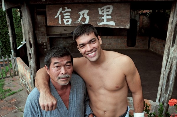Yoshizo e Lyoto no quintal da casa do pai sob a placa Shin Sato (nome dos avôs do lutador, que batizaram um sítio que Yoshizo teve no Pará)