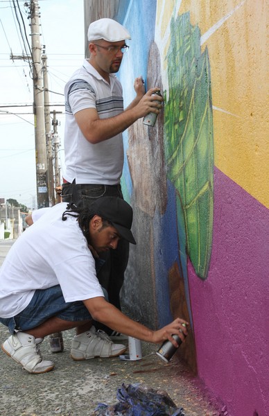 Equipe Opni pintando os grafittes que ilustram o livro