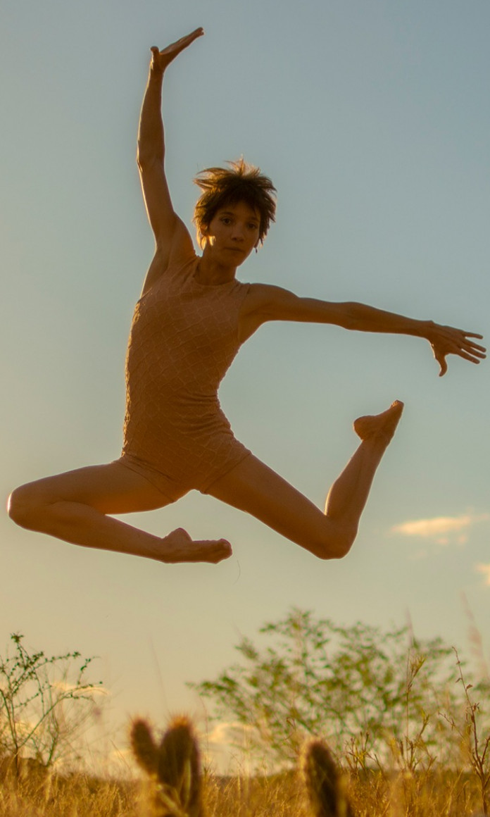 A dançarina e pesquisadora Maria Eugenia Tita faz uma pose no ar em um salto da dança