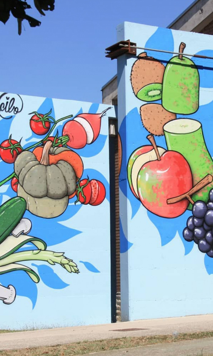 Muro com frutas e legumes coloridos pintados pelo projeto italiano CIBO para cobrir símbolos de ódio de espaços públicos