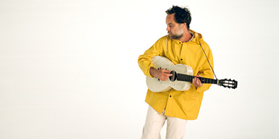 Rodrigo Amarante tocando violão branco
