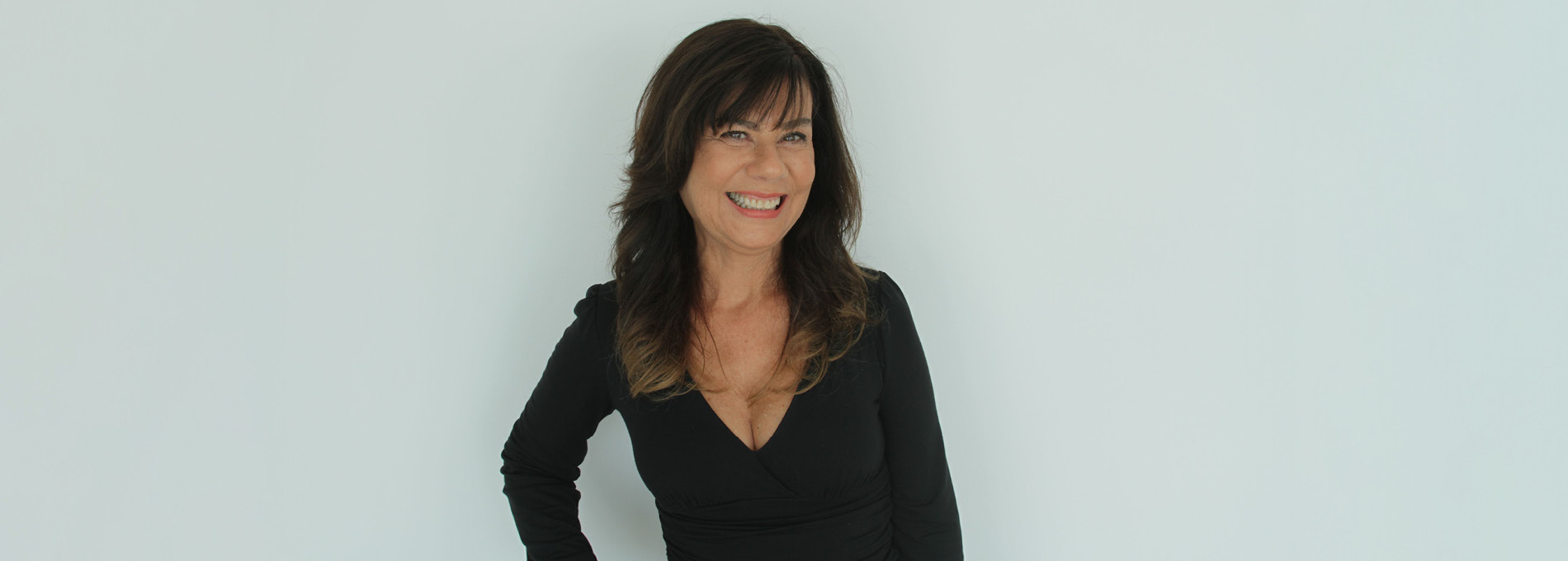 Retrato de Mirian Goldenberg sorrindo vestindo blusa preta e cabelo solto