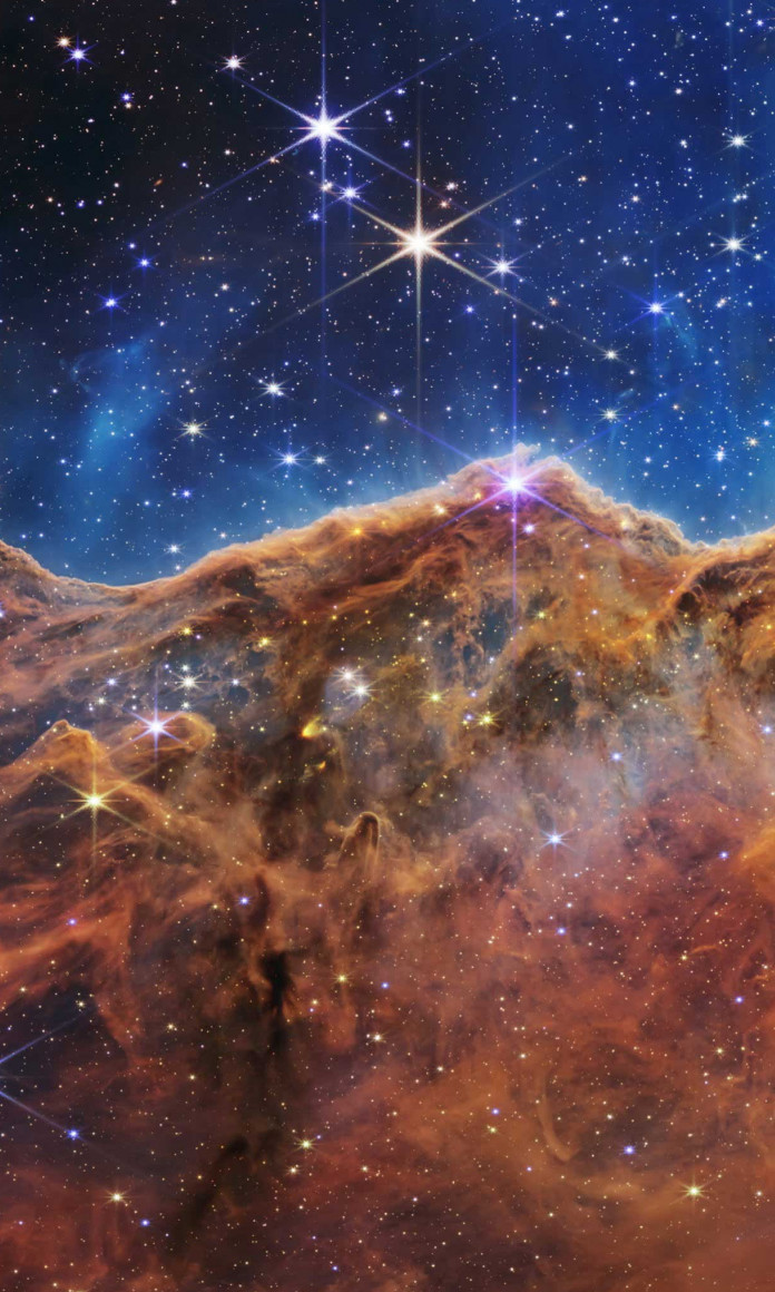 Imagens do ceu feitas pelo telescopio james webb mostram um ceu muito azul sobre montanhas marrons