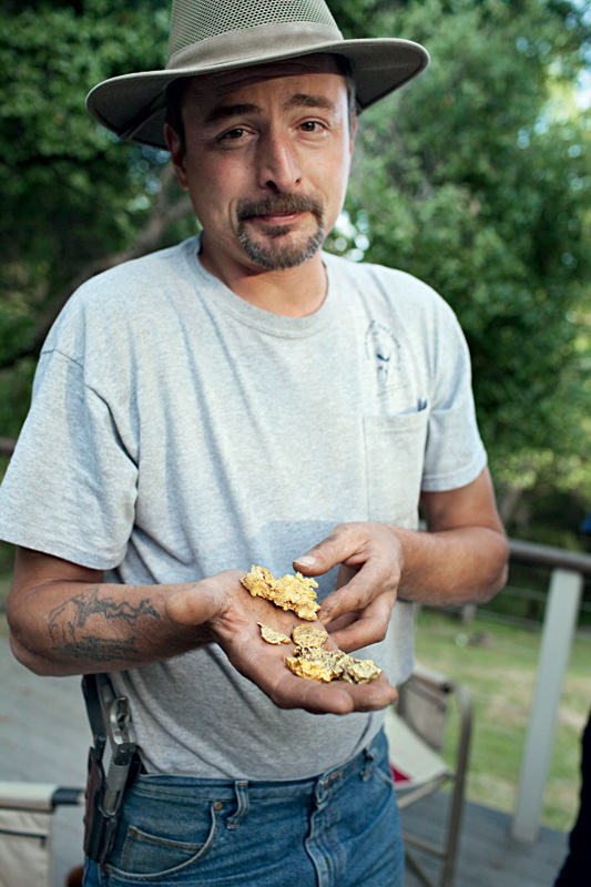 De arma engatilhada, mostra para a rendida reportagem as pepitas que reserva para o futuro caótico que se anuncia