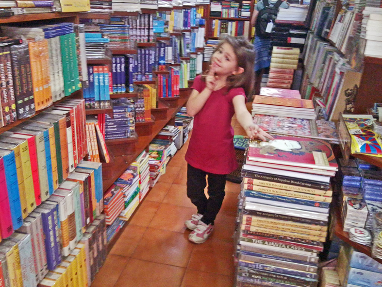 A Grazi escolhendo livrinhos para sua biblioteca mirim.