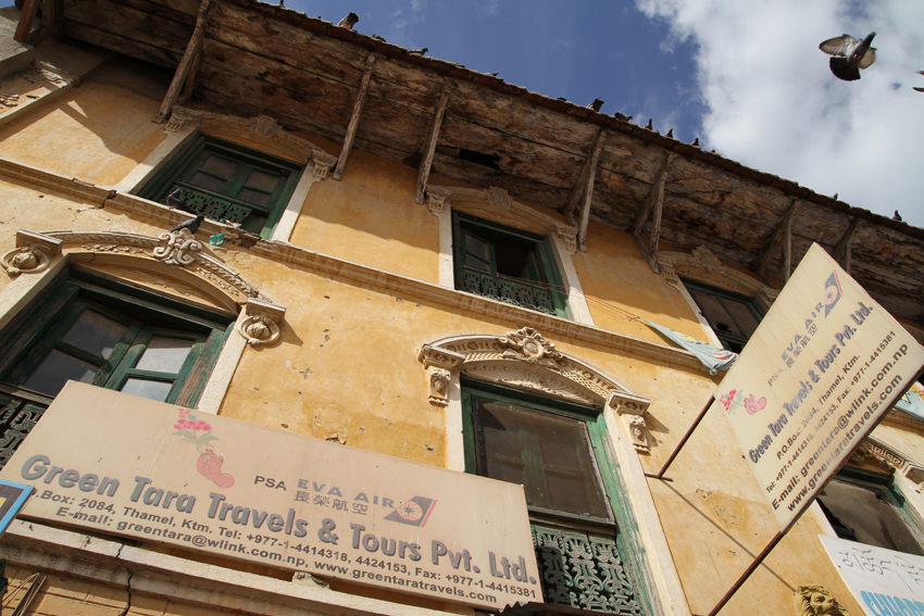Ao redor da estupa ficam centenas de lojinhas, cafés e guest houses. Essa agência de turismo conta com as bençãos da Tara Verde.