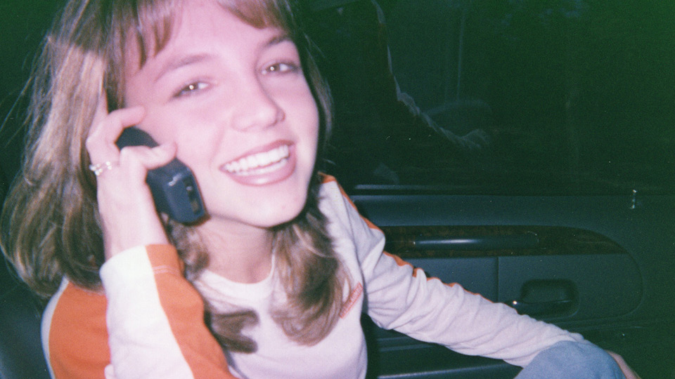 Britney Spears com 16 anos sorrindo no celular