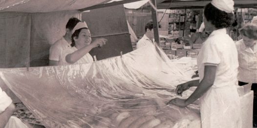 Dona Maria Luisa vendendo sonhos e pães doces na época da barraca La Espanhola